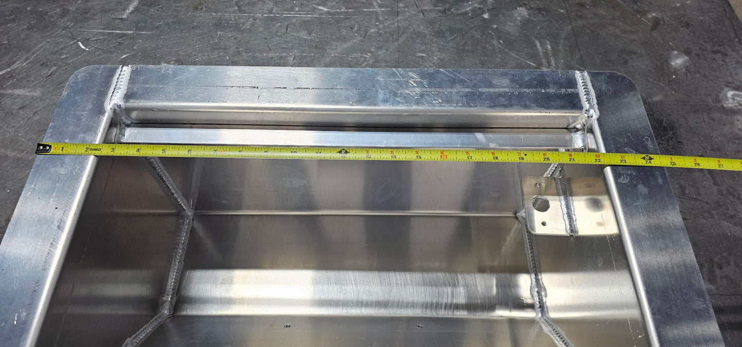 Aluminum winch box on a metal table. There is a tape measure indicating the overall width of the box is 24 1/2" wide.