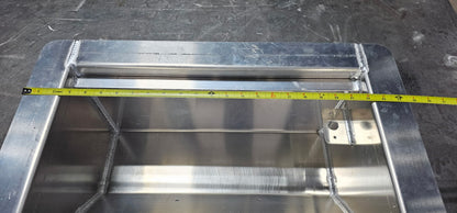 Aluminum winch box on a metal table. There is a tape measure indicating the overall width of the box is 24 1/2" wide.