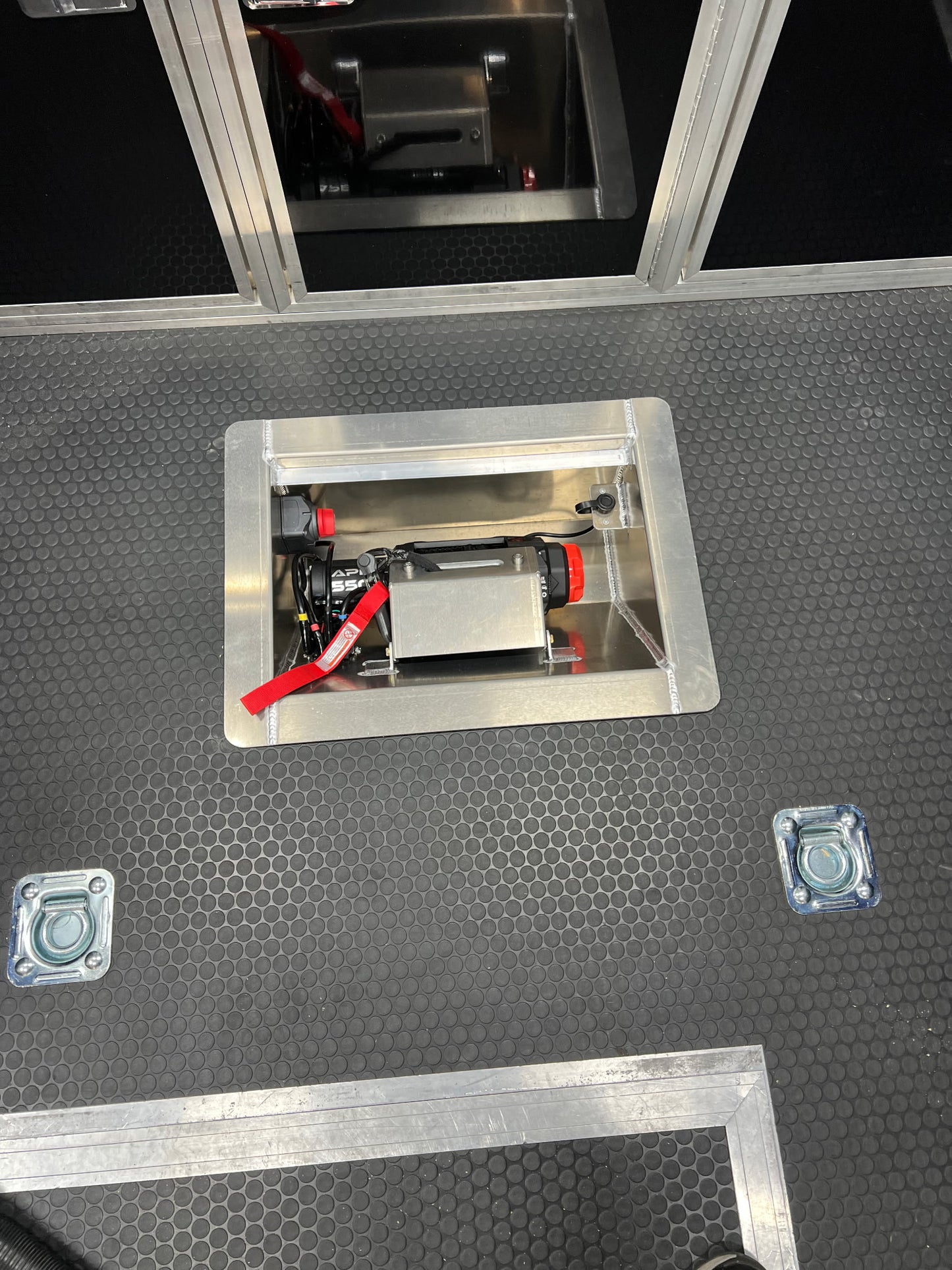 The customer photo of the in line winch box shows the box after it has been installed into the floor of the trailer and before it was been securely bolted into place. 
