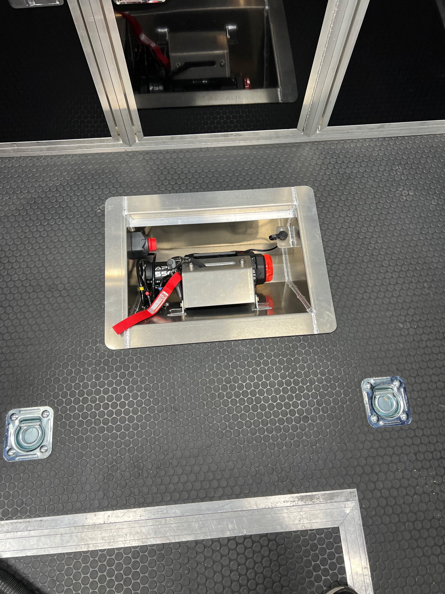 The customer photo of the in line winch box shows the box after it has been installed into the floor of the trailer and before it was been securely bolted into place. 